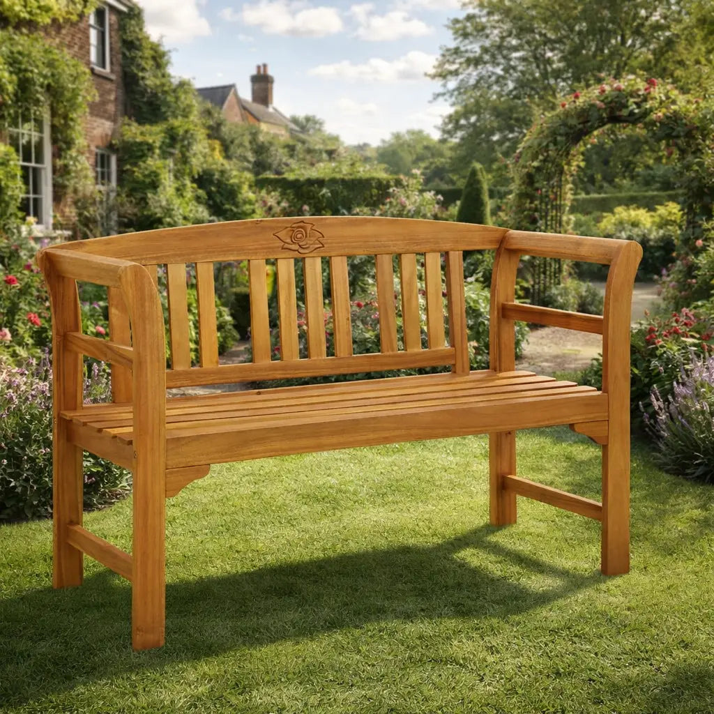 Wooden outdoor garden bench with rose motif in a sunny English garden.