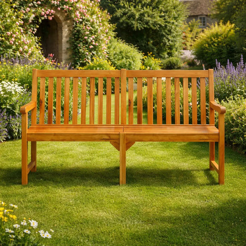 Front view of an extra-wide wooden garden bench on a green lawn, with a floral arch and summer garden background